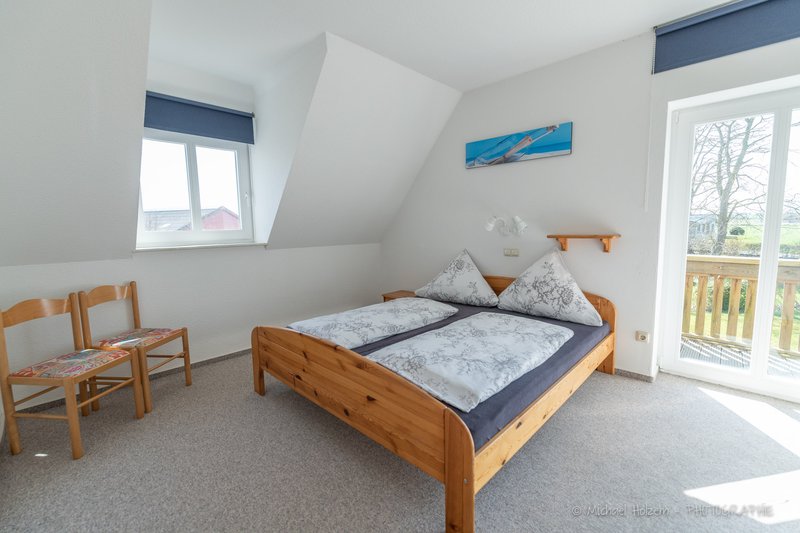 Schlafzimmer mit Doppelbett und Balkonzugang – Ferienwohnung Kappeln