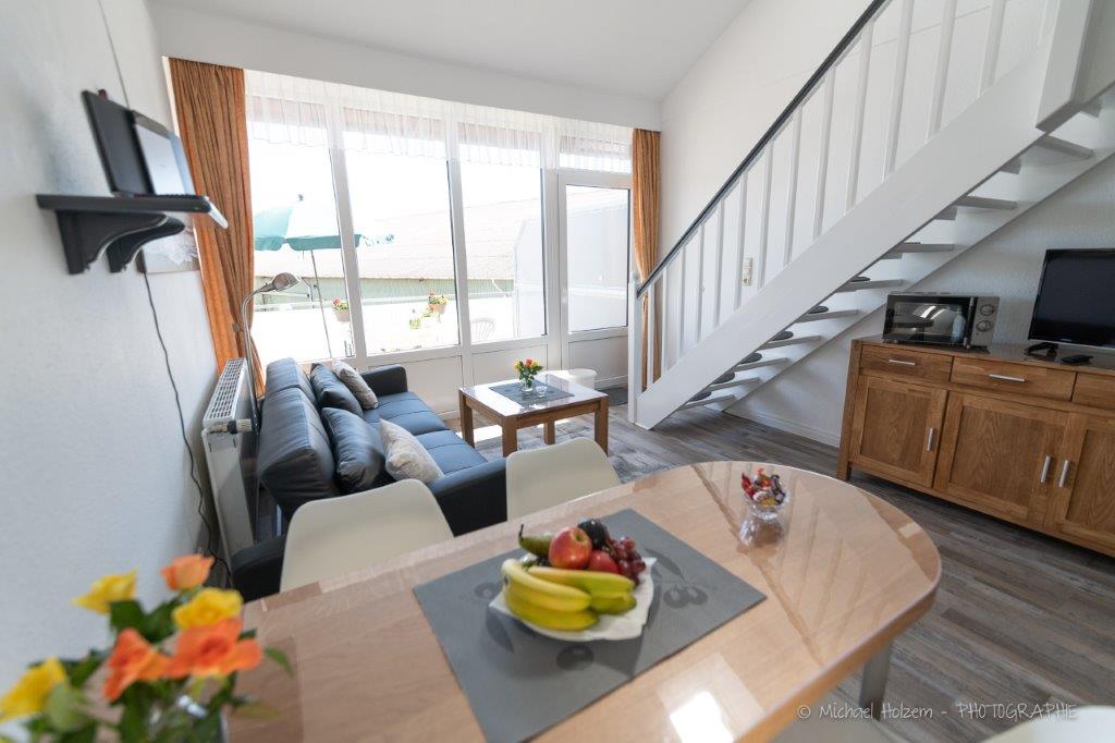 Wohnzimmer mit Balkontür und Gartenblick – Ferienwohnung 4 Personen