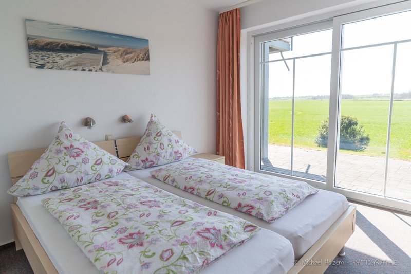 Schlafzimmer mit Terrassentür und Feldblick – Ferienwohnung 8 Personen
